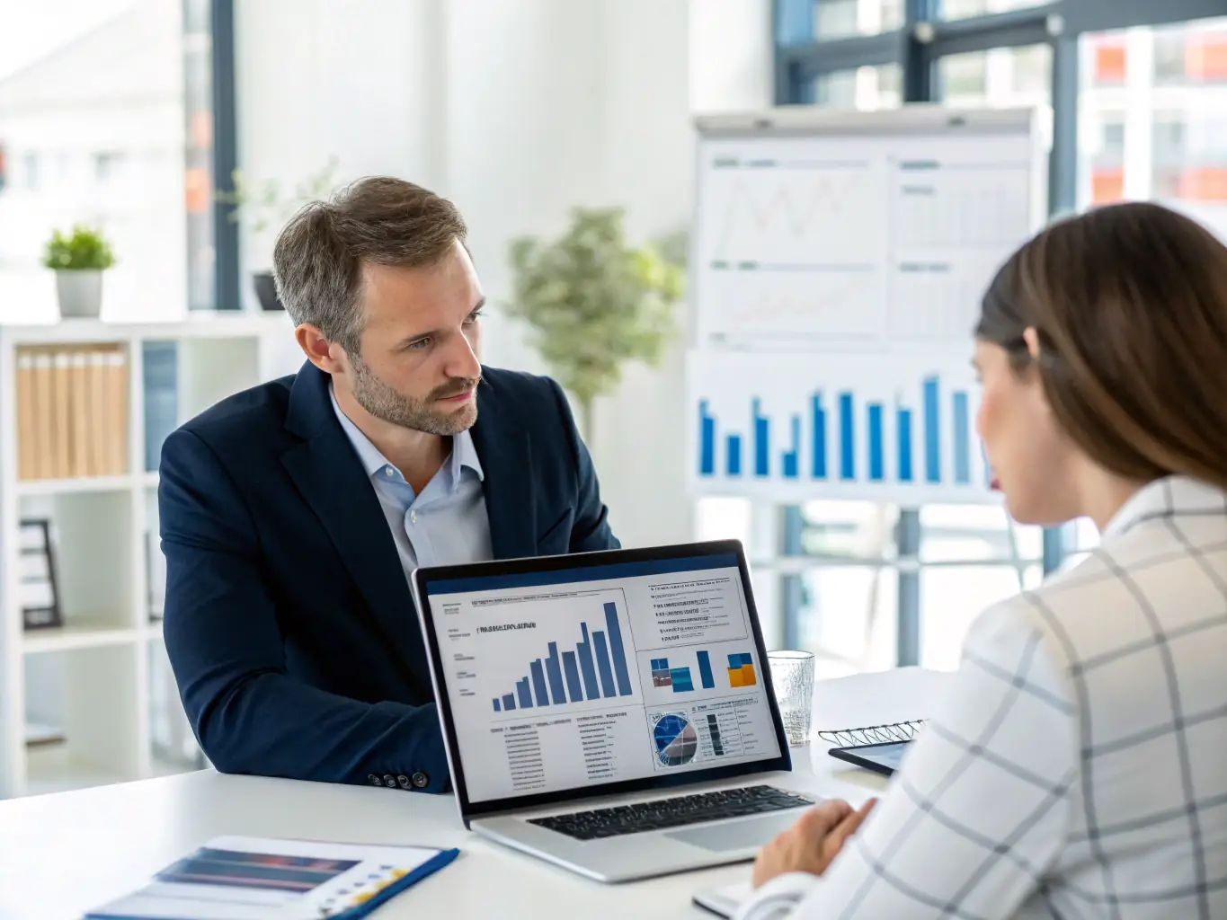 A financial advisor sitting at a desk, reviewing documents with a client in a modern office setting, emphasizing trust and collaboration.